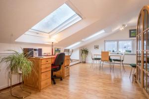 an attic office with a desk and a skylight at Adlerblick in Wangen