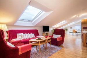 a living room with red furniture and a skylight at Adlerblick in Wangen