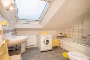 a bathroom with a sink and a washing machine at Adlerblick in Wangen