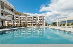 a large swimming pool in front of a building at River side apartment B17 in Herceg-Novi