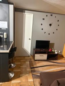 a living room with a clock on the wall at 703 Departamento 15 minutos de Aeropuerto Maipu in Santiago