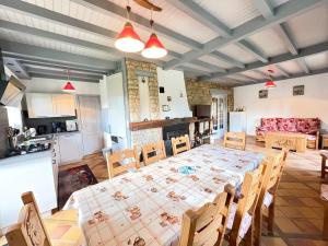 a kitchen and dining room with a table and chairs at La Fermette du Patural in Ramonchamp