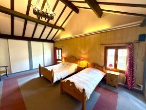 a large bedroom with two beds and a window at La Fermette du Patural in Ramonchamp
