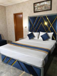 a bedroom with a large bed with a blue headboard at Star Hotel Lahore in Lahore