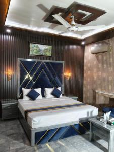 a bedroom with a large bed with a blue headboard at Star Hotel Lahore in Lahore