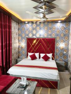 a bedroom with a bed and a red wall at Star Hotel Lahore in Lahore