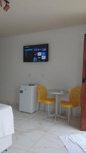 a kitchen with a table and two yellow chairs at Cantinho do sol in Maceió