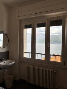 a bathroom with a window with a view of the water at Lake Como Hostel in Menaggio +83 photos