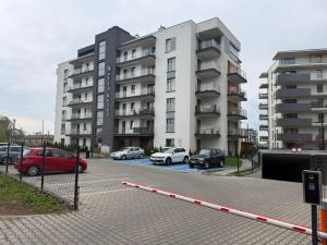 a parking lot with cars parked in front of a building at Kutnowska Perła in Kutno
