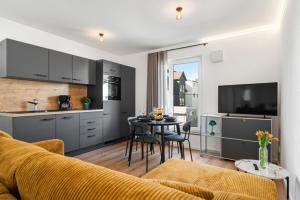 a living room with a kitchen and a table with chairs at Studio 03 - Einzimmerapartment klimatisiert in Friedrichshafen