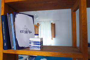 a shelf with a vase and books on it at A casa di Gennarino in Cetara