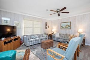 a living room with couches and a flat screen tv at Beaching & Griping by Oak Island Accommodations in Oak Island