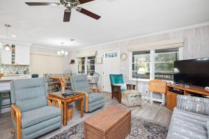a living room with a couch and chairs and a tv at Beaching & Griping by Oak Island Accommodations in Oak Island +55 photos