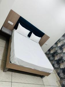 a bed with two pillows on it in a room at Hotel Loya Bti in Bathinda