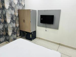 a room with a bed and a cabinet with a tv at Hotel Loya Bti in Bathinda
