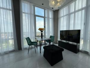 a living room with a table with chairs and a television at Delmar Apartment Center in Dnipro