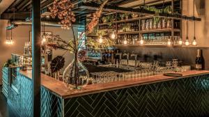 a bar with a wooden counter with glasses at Summio Vakantiepark Schaijk in Schayk