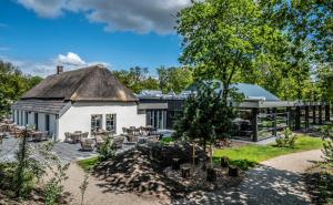 a large white building with a thatched roof at Summio Vakantiepark Schaijk in Schayk
