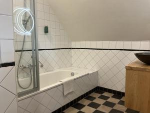 a bathroom with a bath tub and a sink at Graanzicht in Midwolda +34 photos