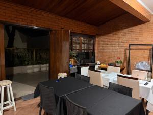 a dining room with a black table and chairs at Pousada Solar Curitiba in Curitiba