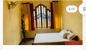 a bedroom with a bed and a window at Celestial Homestay in Wayanad