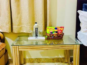 a glass table with a drink and snacks on it at Hotel Keptown in Patna