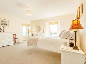 a white bedroom with a large bed and a lamp at 4 Bed in Brechin oc-89698 in Brechin
