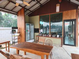 a patio with a wooden table and chairs on a house at เดอะมูนไลท์วิลล่าพะเยา in Phayao