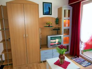 a living room with a cabinet and a tv at Klause-Stüberl in Gaicht