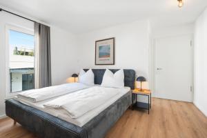 a bedroom with a large bed and a large window at Studio 04 - Einzimmerapartment klimatisiert in Friedrichshafen