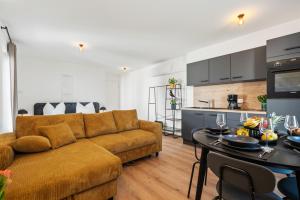 a living room with a couch and a table at Studio 04 - Einzimmerapartment klimatisiert in Friedrichshafen +3 photos