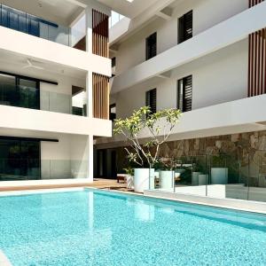 an apartment with a swimming pool in front of a building at Ti Paradis with Private rooftop in Grand-Baie