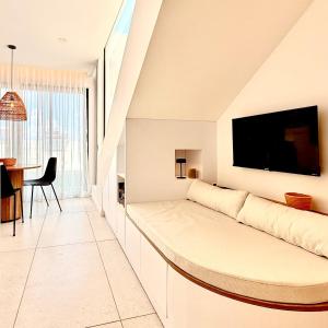 a white living room with a couch and a table at Ti Paradis with Private rooftop in Grand-Baie