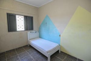 a small room with a small bed with a window at Casa com Churrasqueira e WiFi em Parque Ribeirao in Ribeirão Preto