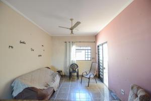 a living room with a bed and a ceiling fan at Casa com Churrasqueira e WiFi em Parque Ribeirao in Ribeirão Preto