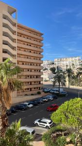 a parking lot with cars parked in front of a building at MIRAMAR V in Torrevieja