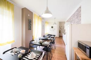 a dining room with tables and chairs and a tv at Panoramic Rooms Salerno in Salerno