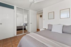 a white bedroom with a bed and a mirror at Beachfront apt with amazing views in Stella