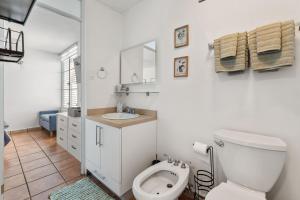 a white bathroom with a toilet and a sink at Beachfront apt with amazing views in Stella +19 photos