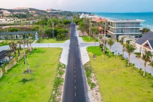 an empty street in a city with palm trees at Polaris Resort & Spa in Xóm Tram