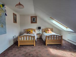 two beds with teddy bears on them in a bedroom at Coast to Coast Accom - Shap in Shap