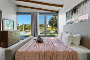 a bedroom with a large bed and a large window at Casa Palma y Sol with private pool in Aguada +23 photos