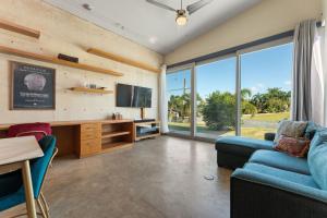 a living room with a blue couch and a tv at Casa Palma y Sol with private pool in Aguada