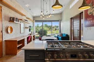 a kitchen with a stove and a living room at Casa Palma y Sol with private pool in Aguada