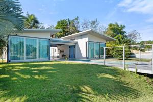 a house with glass windows and a yard at Casa Palma y Sol with private pool in Aguada