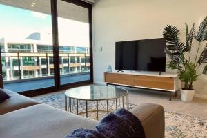 a living room with a tv and a couch and a table at Big, Bold, Barton in Barton