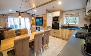 a kitchen and dining room with a wooden table and chairs at Valley 127A - Coghurst Hall in Westfield