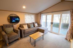 a living room with a couch and a table and a tv at Valley 127A - Coghurst Hall in Westfield +34 photos