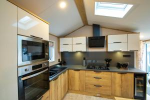 a kitchen with wooden cabinets and a stove top oven at Valley 127A - Coghurst Hall in Westfield