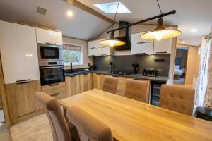 a kitchen with a long wooden table and chairs at Valley 127A - Coghurst Hall in Westfield